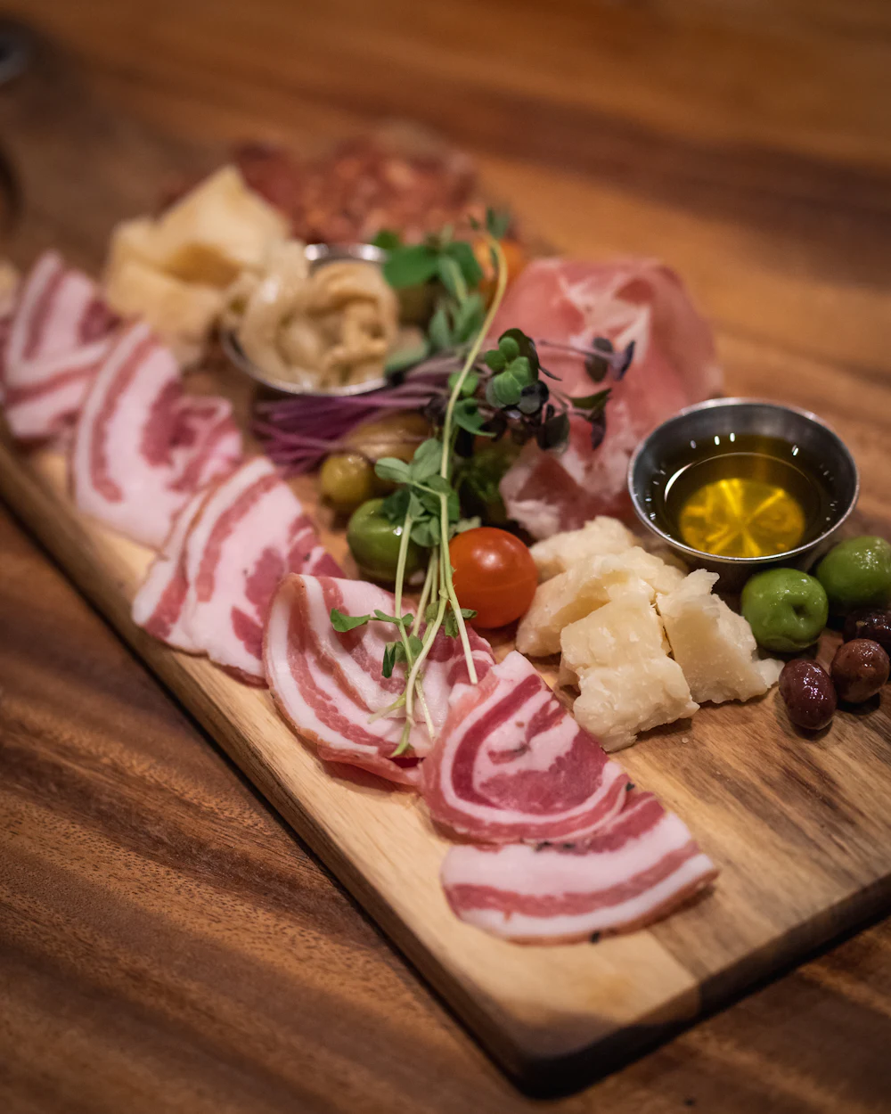 Aperitivo board with sliced rolled pancetta, olives and parmesan